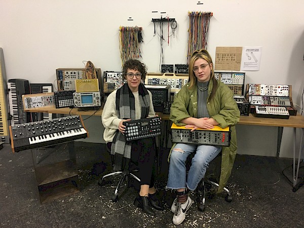 Teacher, artist and Synth Library co-founder Alissa DeRubeis and S1 co-founder Felisha Ledesma with said library, which provides S1 members of all experience levels with hands-on access to modular synthesizers, DJ gear, recording equipment and other electronic instruments